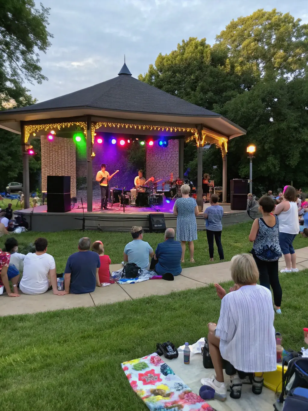 A lively photo of a music concert organized by Foyer Rural de Charleval, featuring musicians performing on stage, with an enthusiastic audience enjoying the music, emphasizing the community's engagement with the event.